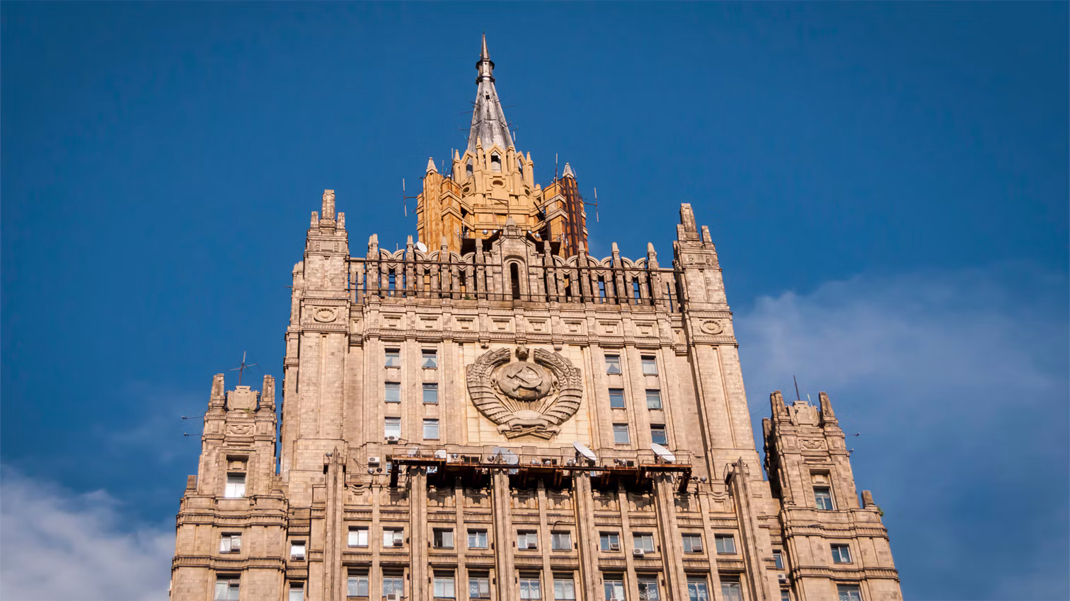 Шпиль на здании МИДа дорисовал к проекту Сталин при бесплодном возмущении архитектора Гельфрейха. Его спроектировали уже в процессе строительства здания. Чтобы облегчить конструкцию, ее обшили жестью, отличающейся по цвету от камня, которым облицовано само здание. После смерти Сталина Гельфрейх направлял Хрущеву письма с требованием убрать шпиль, но тот не проявил интереса